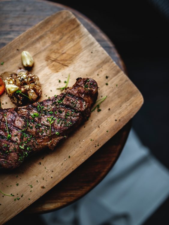 A perfectly grilled steak on a chopping board.