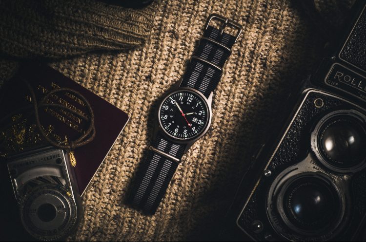 A flatlay photo of a striped canvas watch.