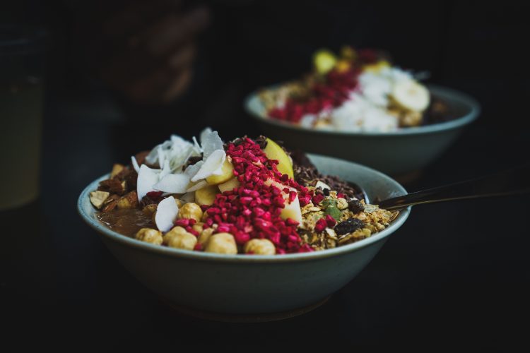 A bowl of nutritious food, composed of fruits and nuts.